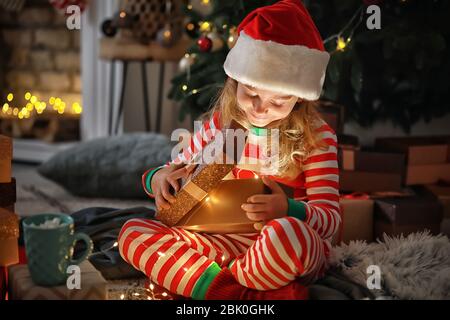 Süße kleine Mädchen öffnen magic Geschenk zu Weihnachten zu Hause Stockfoto