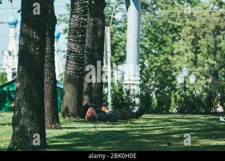 Moskau, Russland - 31. Mai 2014: Ein Obdachloser schläft auf dem Rasen in der Stadt Moskau Stockfoto