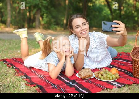 Glückliche Mutter und Tochter unter selfie beim Picknick im Freien Stockfoto