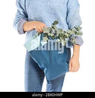 Frau mit Buch und Eukalyptus in eco Beutel auf weißem Hintergrund, Nahaufnahme Stockfoto