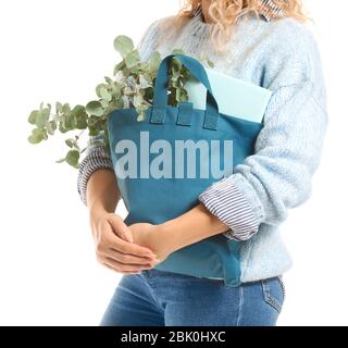 Frau mit Buch und Eukalyptus in eco Beutel auf weißem Hintergrund, Nahaufnahme Stockfoto