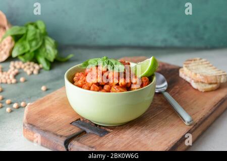 Schüssel mit leckerem Kichererbse in Tomatensauce auf Tisch Stockfoto