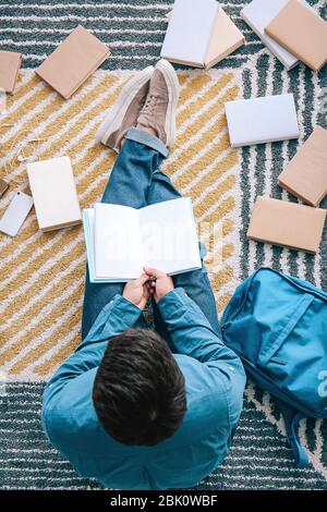 Asiatische Kursteilnehmer mit einer Menge Bücher Vorbereitung auf die Prüfung zu Hause Stockfoto