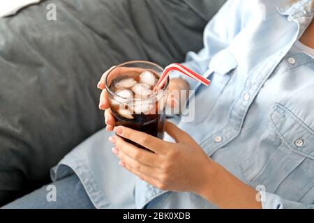Frau trinkt lecker Cola zu Hause Stockfoto