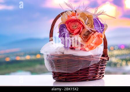 Blumenstrauß aus Kunstblumen in einem Holzkorb mit Edelsteinen und Perlen verziert. Stockfoto