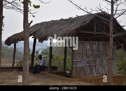 Bhopal, Madhya Pradesh/Indien : 15. Januar 2020 - EIN Mann sitzt in einer Tribal Hütte in Manav Sangrahalaya Bhopal Stockfoto