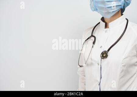 Cropped Ansicht der weiblichen Arzt posiert mit Stethoskop in Uniform. Gesundheitssystem Arbeiter in weißer Uniform und chirurgische Handschuhe. Medizin, Gesundheitswesen Stockfoto