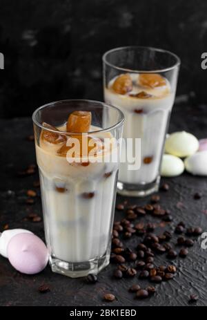 Gefrorener, gebrauter Kaffee in Eiswürfeln auf einem dunklen, strukturierten Hintergrund in Glasgläsern Stockfoto