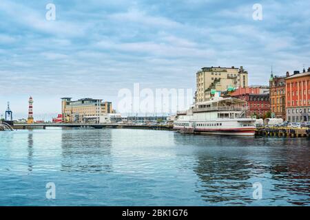 Malmo Binnenhafen mit dem alten Leuchtturm auf der Brücke Universitetsbron aus dem Wasser an einem bewölkten Tag gesehen. Stockfoto