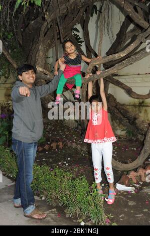 Nathdwara, Rajasthan, Indien, Asien - 23. Januar 2014 - Indische glückliche kleine süße Mädchen Swing auf dem Baum Stockfoto