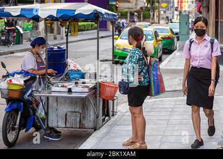 Street Food Verkäufer mit Facemask und Kunde während der Covid 19 Pandemie, Bangkok, Thailand Stockfoto