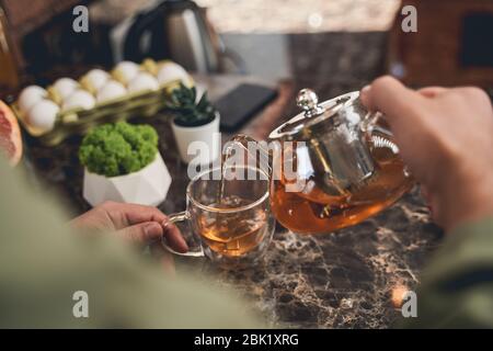 Männlich brauen schwarzen Tee in der Küche Stockfoto
