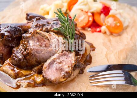 Gebratener Schweinshaxe mit Gemüse und Rosmarin. Stockfoto