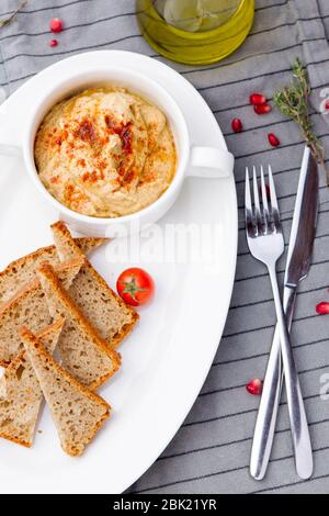 Veganer Hummus, hergestellt aus Kichererbsen und Tahini, mit Olivenöl und Knoblauch. Stockfoto