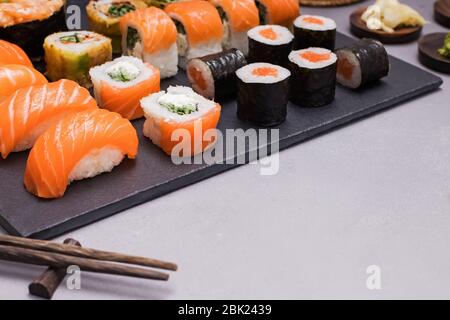 Set Sushi und Maki Rollen mit Wasab auf schwarzem Steintablett Stockfoto