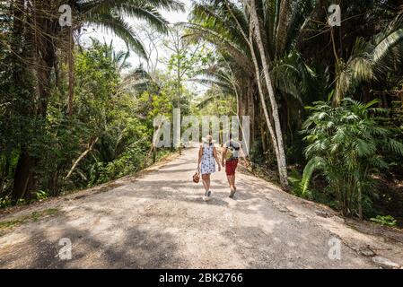 Kohunlich, Mexiko - 25. April 2019: Ein Paar geht durch den Wald zu den Ruinen der alten Maya-Stadt Kohunlich in Quintana Roo, Yucatan Pen Stockfoto