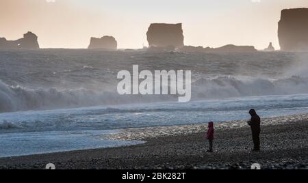 Unerkannte Leute, die den schönen Reynisfjara Strand mit stürmischen Atlantischen Wellen genießen, bei Vik i Mydral in Island Stockfoto