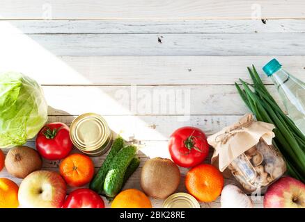 Verschiedene Produkte auf einem weißen Holztisch, flaches Lay. Platz für Text. Konzept des Kaufs von Lebensmitteln in einer Krise. Draufsicht. Stockfoto