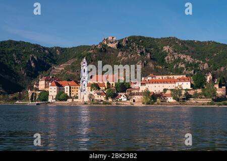 Stadtbild von Dünstein mit dem blau-weißen barocken Klosterkirche-Turm und dem Schloss Kuenringer an der Donau in der Wachau, Österreich Stockfoto