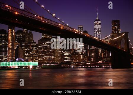 Blick auf die nächtliche Szene der Brooklyn Bridge und der Skyline von Manhattan bei Nacht, vom Empire Fulton Ferry Park aus gesehen. Stockfoto