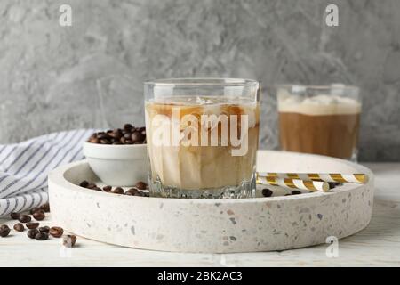 Komposition mit Tablett mit Eiskaffee auf Holzhintergrund Stockfoto