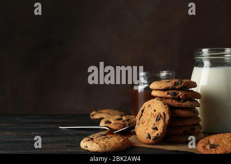 Zusammensetzung mit Chip Cookies, Milch und Karamell auf Holztisch Stockfoto