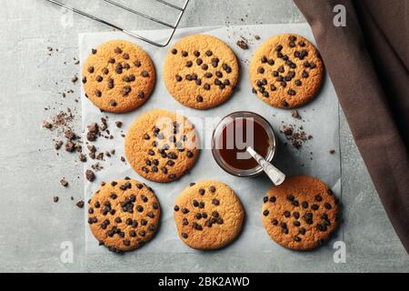 Zusammensetzung mit Chip Cookies und Karamell auf grauem Tisch Stockfoto