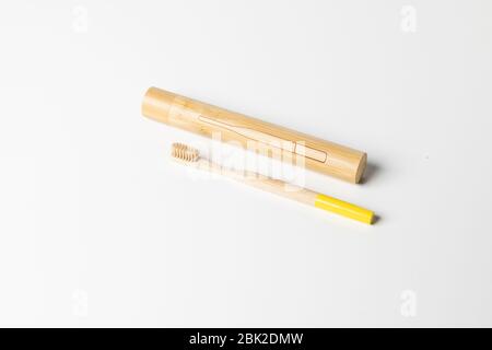 Holzzahnbürste mit Holzkiste aus Bambus auf weißem Hintergrund. Stockfoto