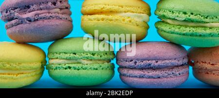 Mehrfarbige runde gebackene Macarons Kuchen auf blauem Hintergrund, Banner Stockfoto