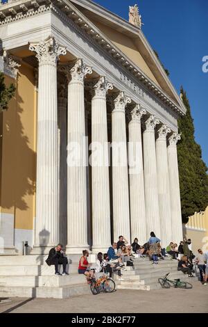 Menschen vor dem Zappeion Gebäude in den Nationalen Gärten von Athen, Griechenland. Genießen Sie die Sonne trotz Coronavirus-Epidemie Stockfoto