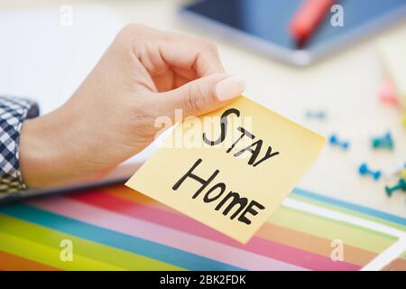 Menschliche Hand hält Klebe Notiz mit Stay Home Text Stockfoto