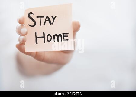 Handgehaltener Haftnotiz mit Stay Home-Text Stockfoto