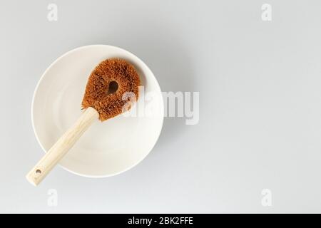 Runde, abfallfreie Kokosnussbürste und weiße Schale für nachhaltige Hausreinigung Stockfoto