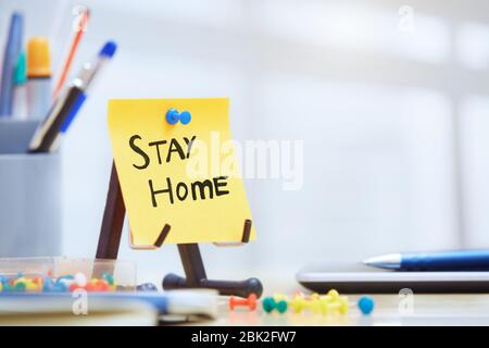 Stay Home Text auf Haftnotiz im Büro Stockfoto