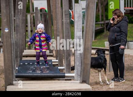 01. Mai 2020, Mecklenburg-Vorpommern, Grevesmühlen: Die zweijährige Elli-Marie spielt mit ihrer Mutter Ann-Karthrin Wulff auf dem Spielplatz der Bürgerwiese. Pünktlich zum 1. Mai hat die Landesregierung Mecklenburg-Vorpommerns die Spielplätze nach wochenlanger Schließung im Rahmen der Corona-Schutzmaßnahmen wieder eröffnet. Foto: Jens Büttner/dpa-Zentralbild/dpa Stockfoto