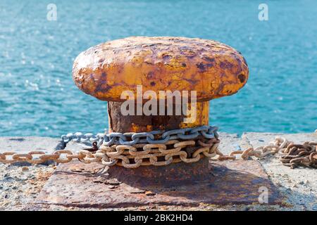 Große oarange alte rostige Anlegestelle auf einem Dock gebissen, blaues Wasser Hintergrund, erschossen in Vulkan äolischen Insel. Stockfoto