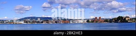 Oslo, Ostlandet / Norwegen - 2019/09/02: Panoramablick auf die Küste von Oslo mit Akershus Festung, Rathaus und Aker Brygge Bezirk am Pipervika Hafen Stockfoto