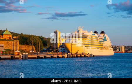 Oslo, Ostlandet / Norwegen - 2019/09/02: Panoramablick auf die Hafenpromenade von Oslo mit der Festung Aker Brygge Oslo und dem Kreuzfahrtschiff, das in Pipervika andockt Stockfoto