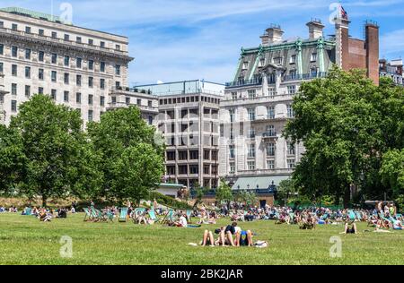 Eine Vielzahl von Sonnenanbetern im Green Park, London, England, Großbritannien. Stockfoto