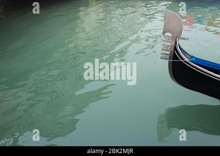 Fragment einer Gondel, die durch einen Kanal in Venedig fährt. Abstrakte Reflexionen im Wasser Stockfoto