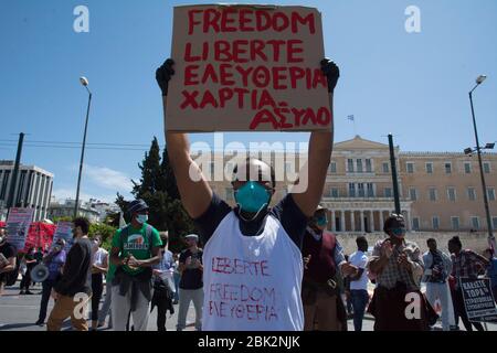 Athen, Griechenland. Mai 2020. Flüchtlinge ehren den 1. Mai mit Plakaten vor dem parlament. Tausende gingen auf die Straße, um gegen die bevorstehende Austeritätspolitik aufgrund der Pandemie von Covid-19 zu protestieren, indem sie soziale Distanz praktizierten und Masken trugen. Quelle: Nikolas Georgiou/ZUMA Wire/Alamy Live News Stockfoto