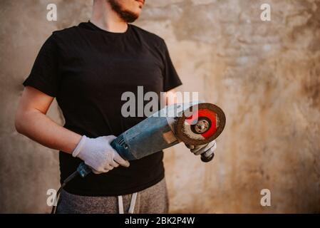 Ein junger Kaukasusmann hält eine Mühle in der Hand Stockfoto