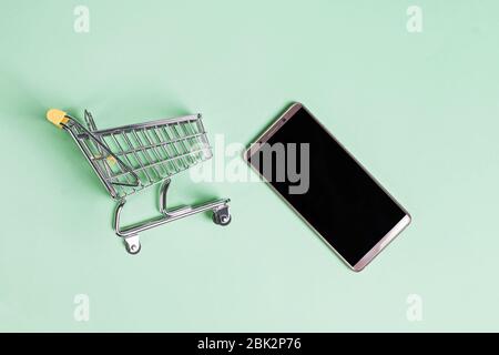 Smartphone und Mini-Trolley, Draufsicht Stockfoto