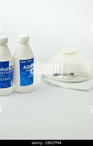 Alkoholflasche mit n95 medizinische Maske auf weißem Hintergrund Stockfoto