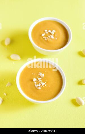 Nahaufnahme von Erdnusssauce in Schalen über gelbem Hintergrund. Stockfoto
