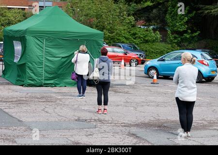 Die öffentliche Warteschlange zu Fuß hält einen Abstand von 2 Metern auf Covid-19-Tests an einem Pop-up-mobilen Testgelände in Rugby Warwickshire UK Stockfoto