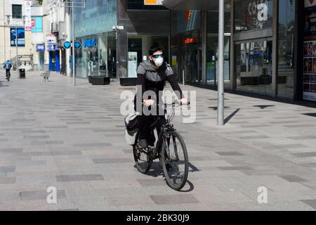 09.04.20 - EIN Radfahrer mit einer schützenden Gesichtsmaske fährt in Richtung Hayes, Cardiff Stockfoto