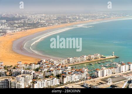 Weiße moderne Architektur rund um den unglaublich breiten Sandstrand in Agadir, Marokko, Nordafrika Stockfoto