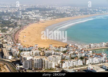 Weiße moderne Architektur rund um den unglaublich breiten Sandstrand in Agadir, Marokko, Nordafrika Stockfoto