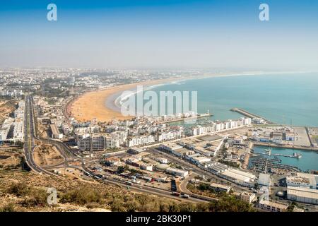 Weiße moderne Architektur rund um den unglaublich breiten Sandstrand in Agadir, Marokko, Nordafrika Stockfoto